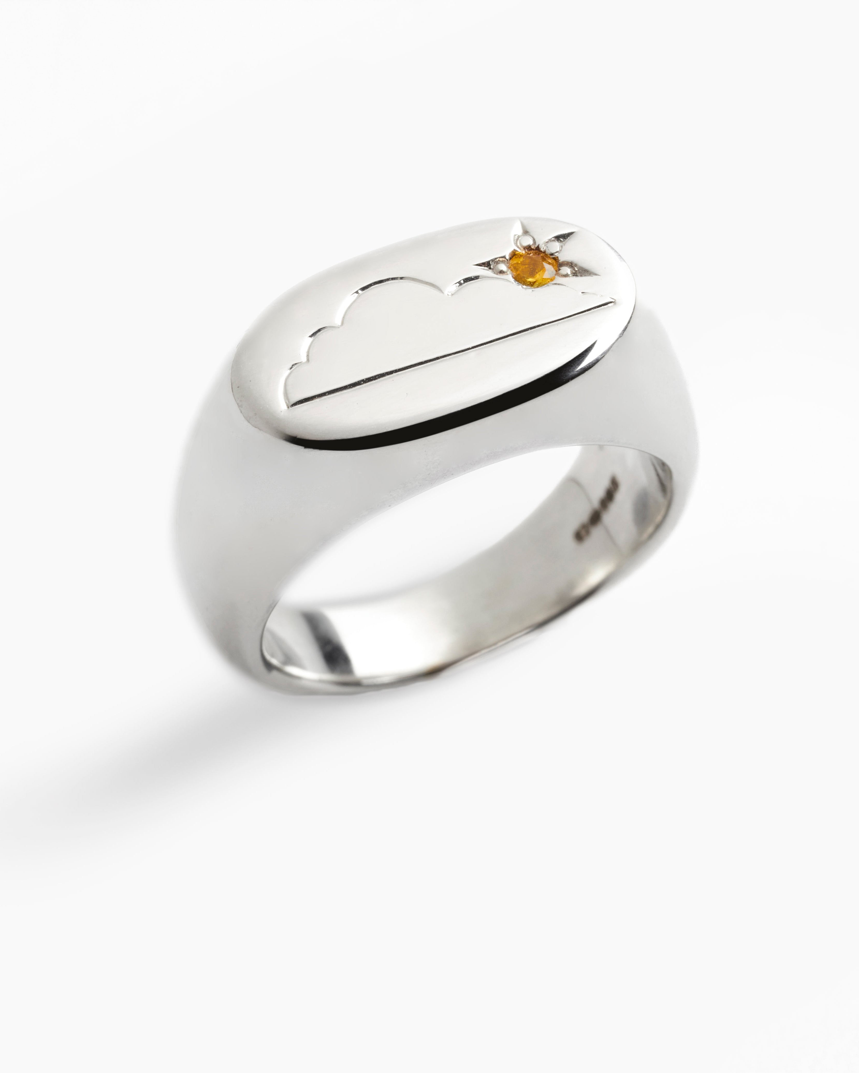 Silver ring with cloud and sun design on a white background